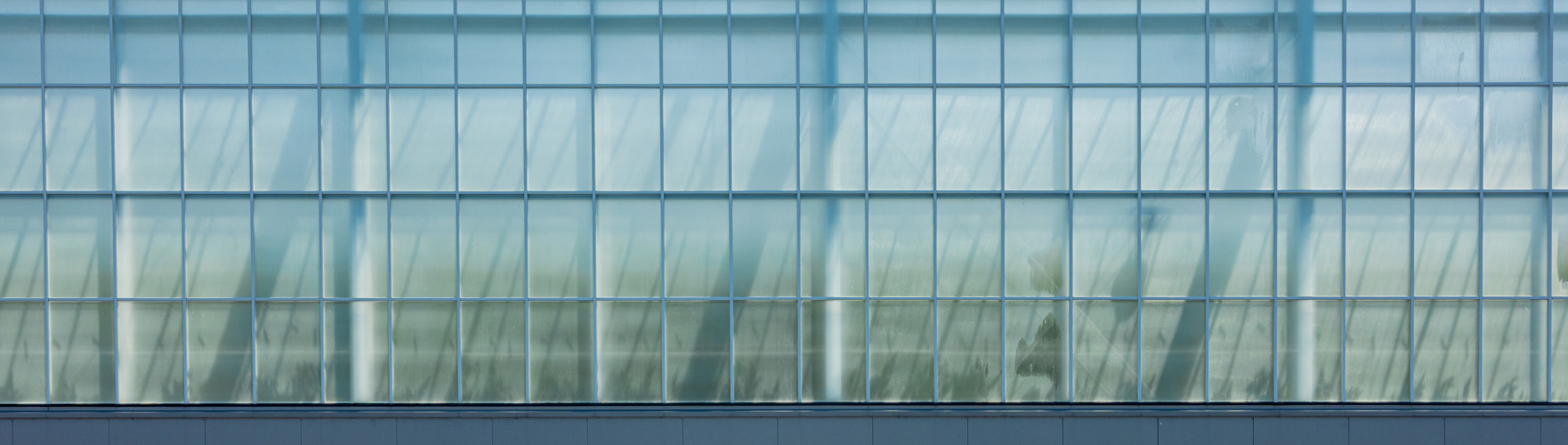 zijaanzicht van een glazen kas met doek met stralend blauwe lucht